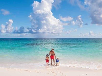 Father and sons walking on beach