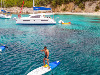 Catamaran Anchoring and People Stand Up Paddling Corfu Island