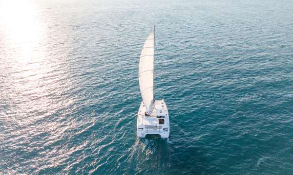 A sailing catamaran underway under full sail.