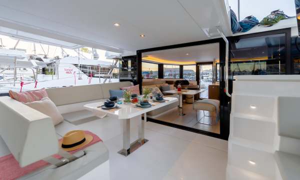 Moorings 4300 cockpit with a dining table, opening aft to the saloon settee beyond.