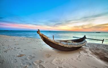 a boat sitting on top of a sandy beach