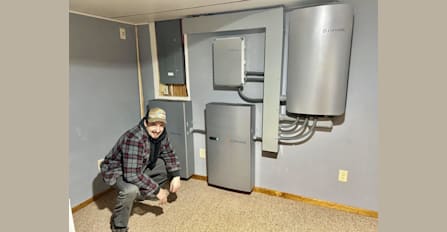 Solar Expert and Installer Matt in front of an Enphase battery storage system they just finished installing.