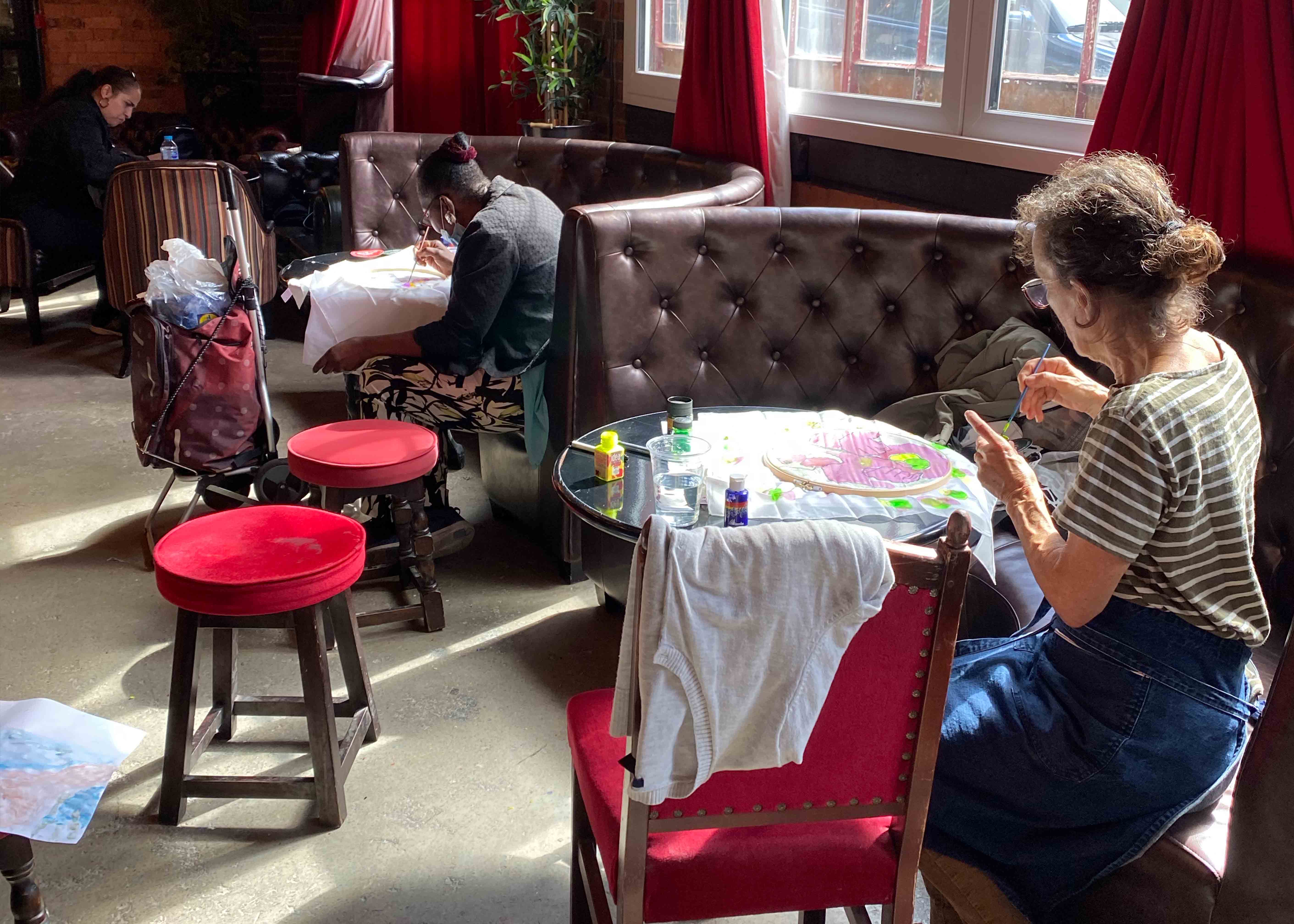 Participants paiting and sat individually in booths in a pub
