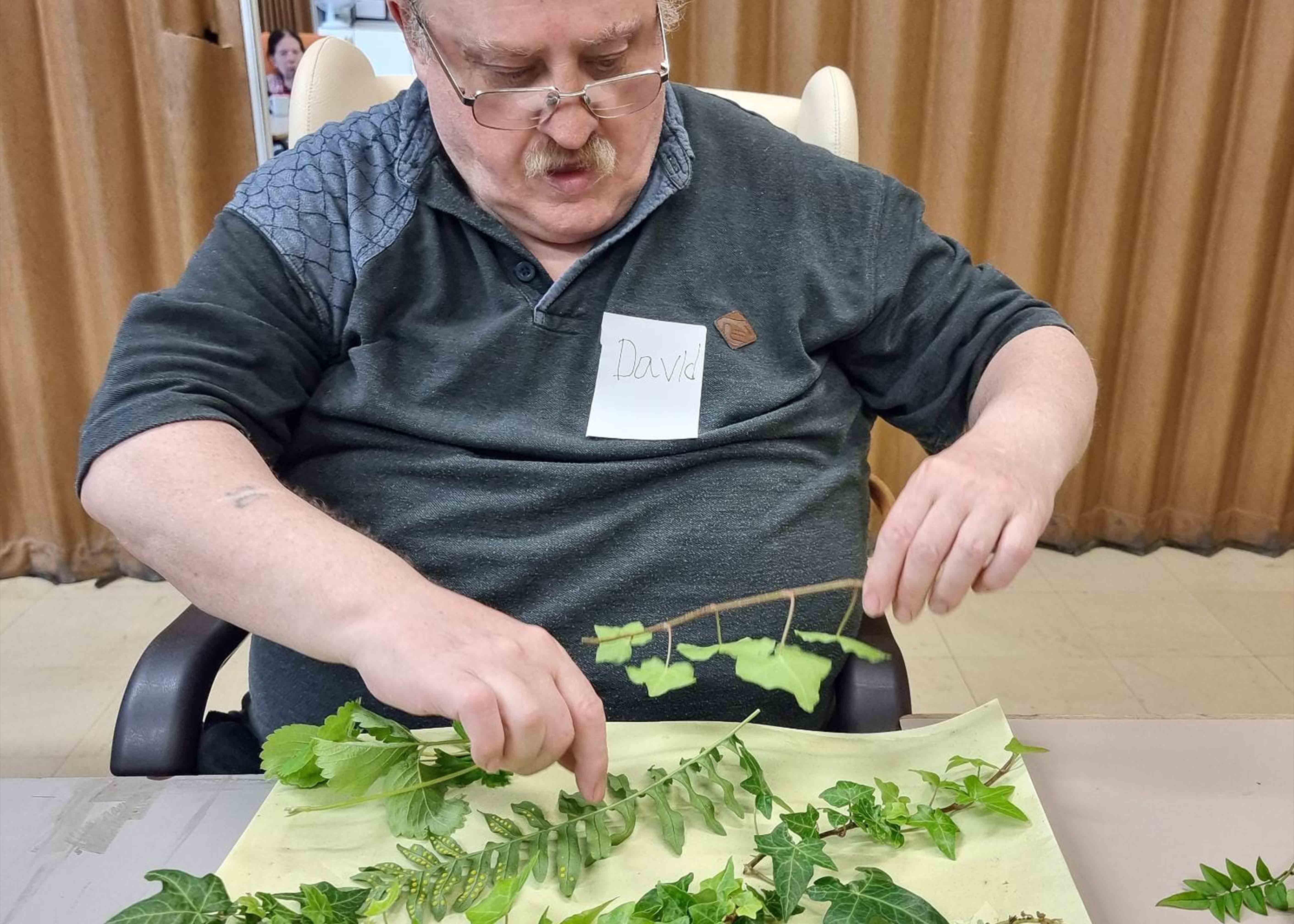 Man creating art with leaves