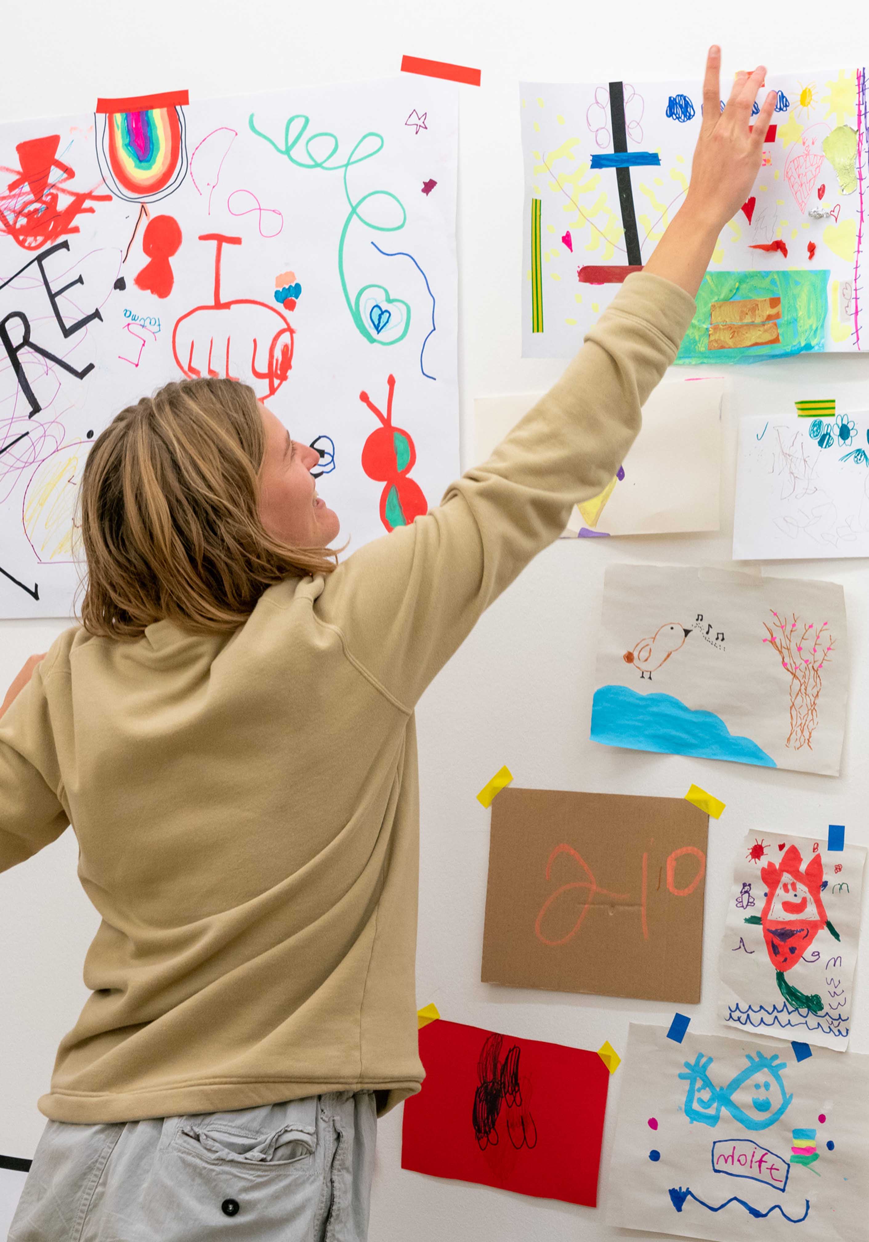 person hanging up drawings