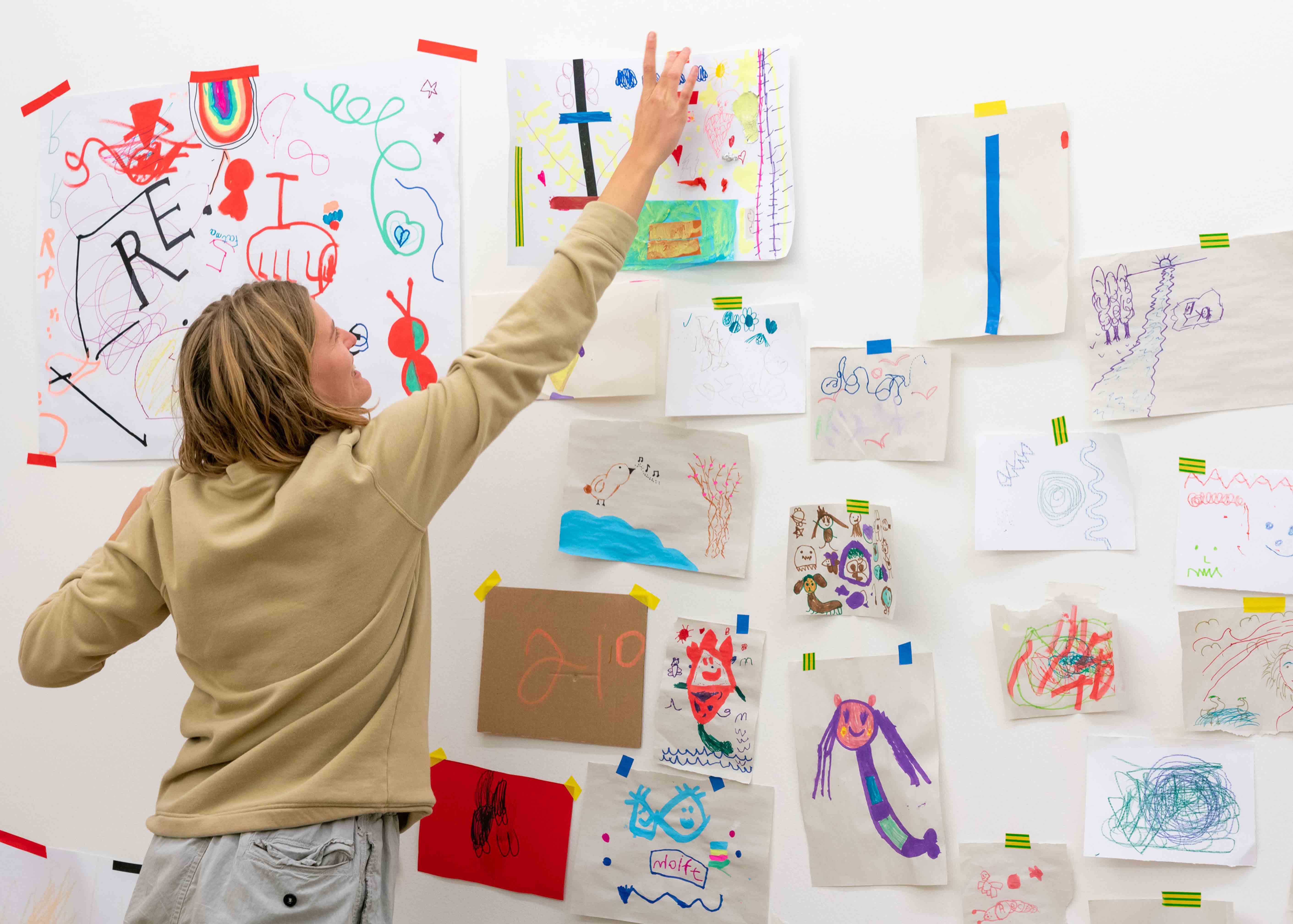 Girl looking at wall of drawings