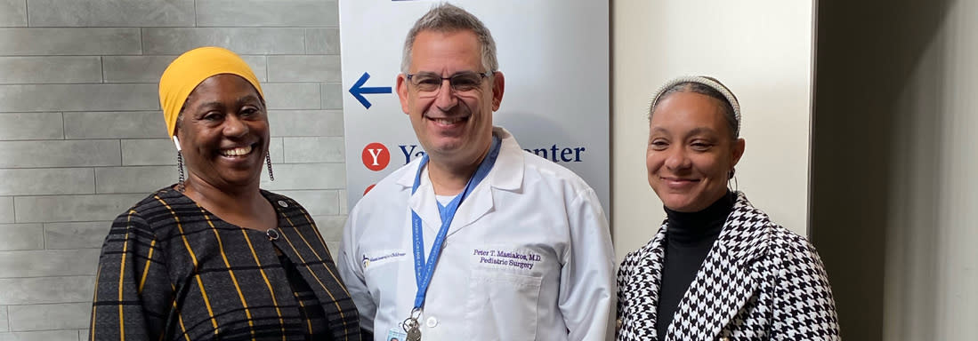 Three people posing for a photo in a hospital