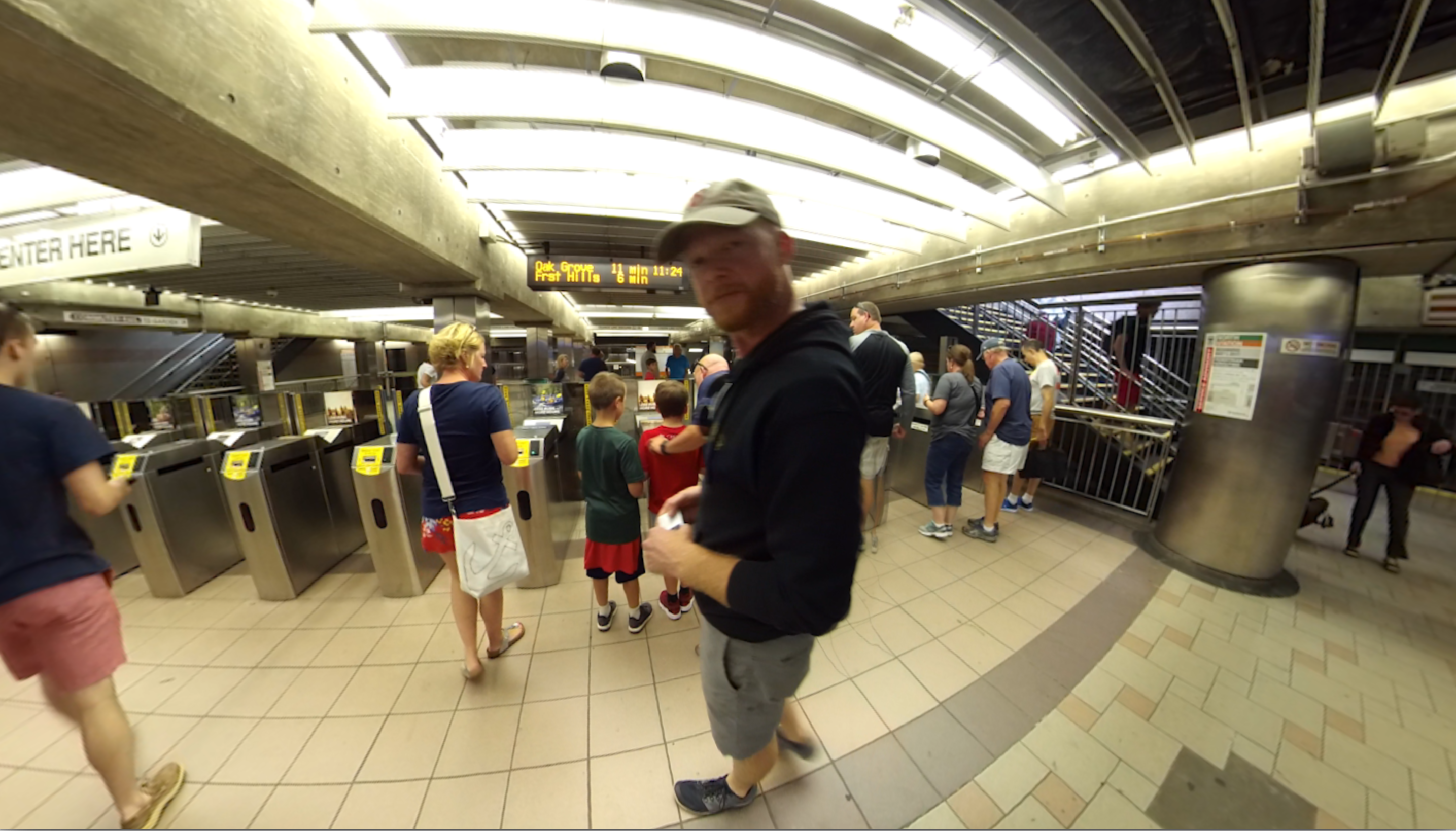 A person standing in an MBTA station near the ticket gates