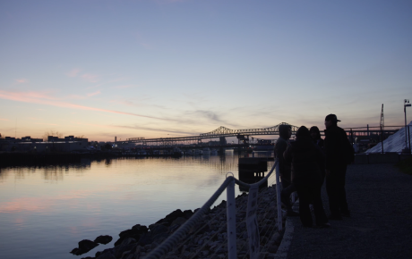 Teenagers standing by a body of water watching a sunset in Chelsea