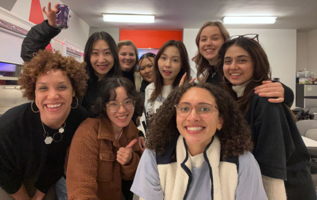 Nine individuals posing for a selfie at the Media Design studio art show