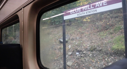 The view out from a Fairmount Line commuter rail train, showing a for the Blue Hills Ave stop