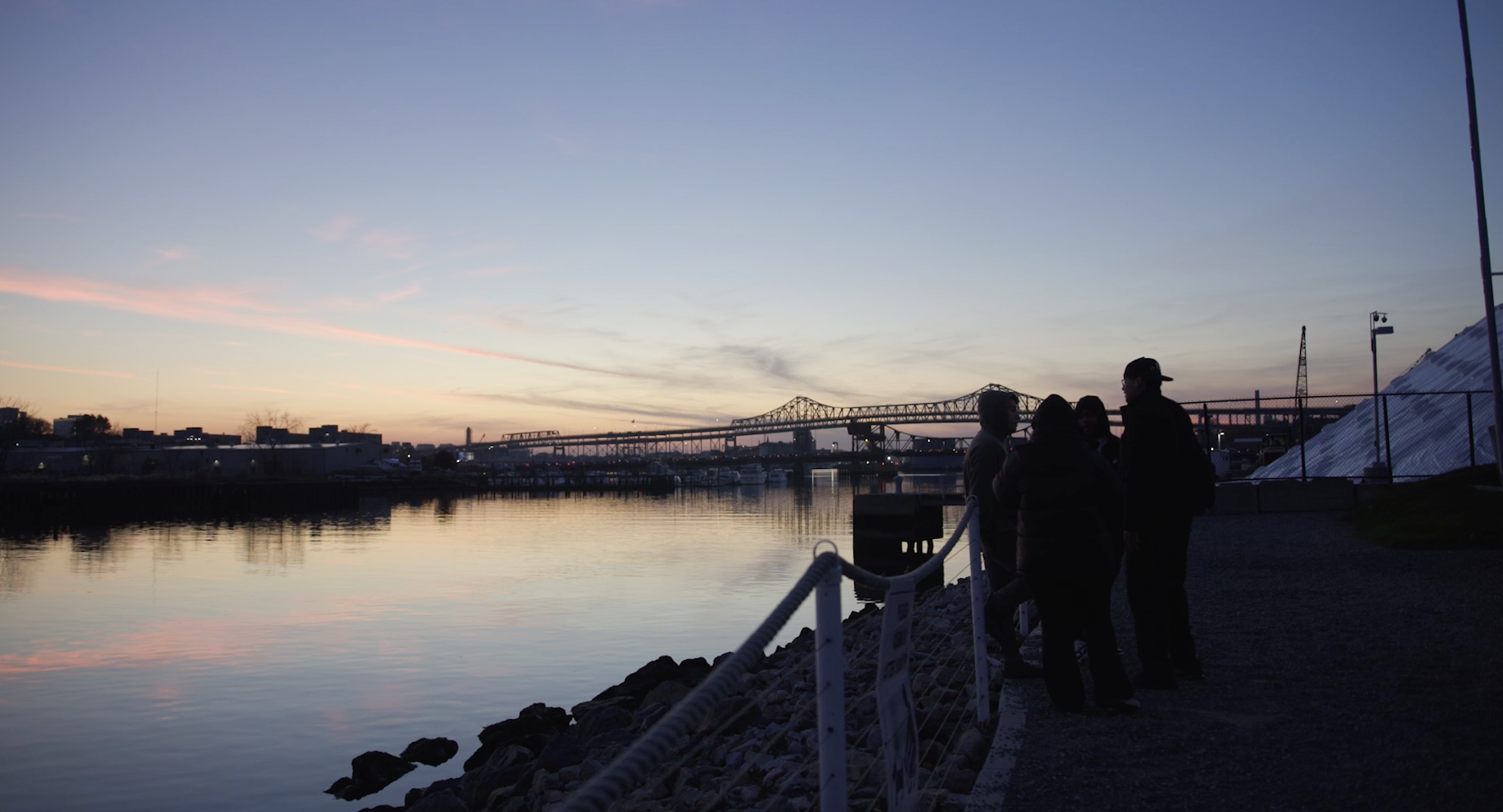 Teenagers standing by a body of water watching a sunset in Chelsea