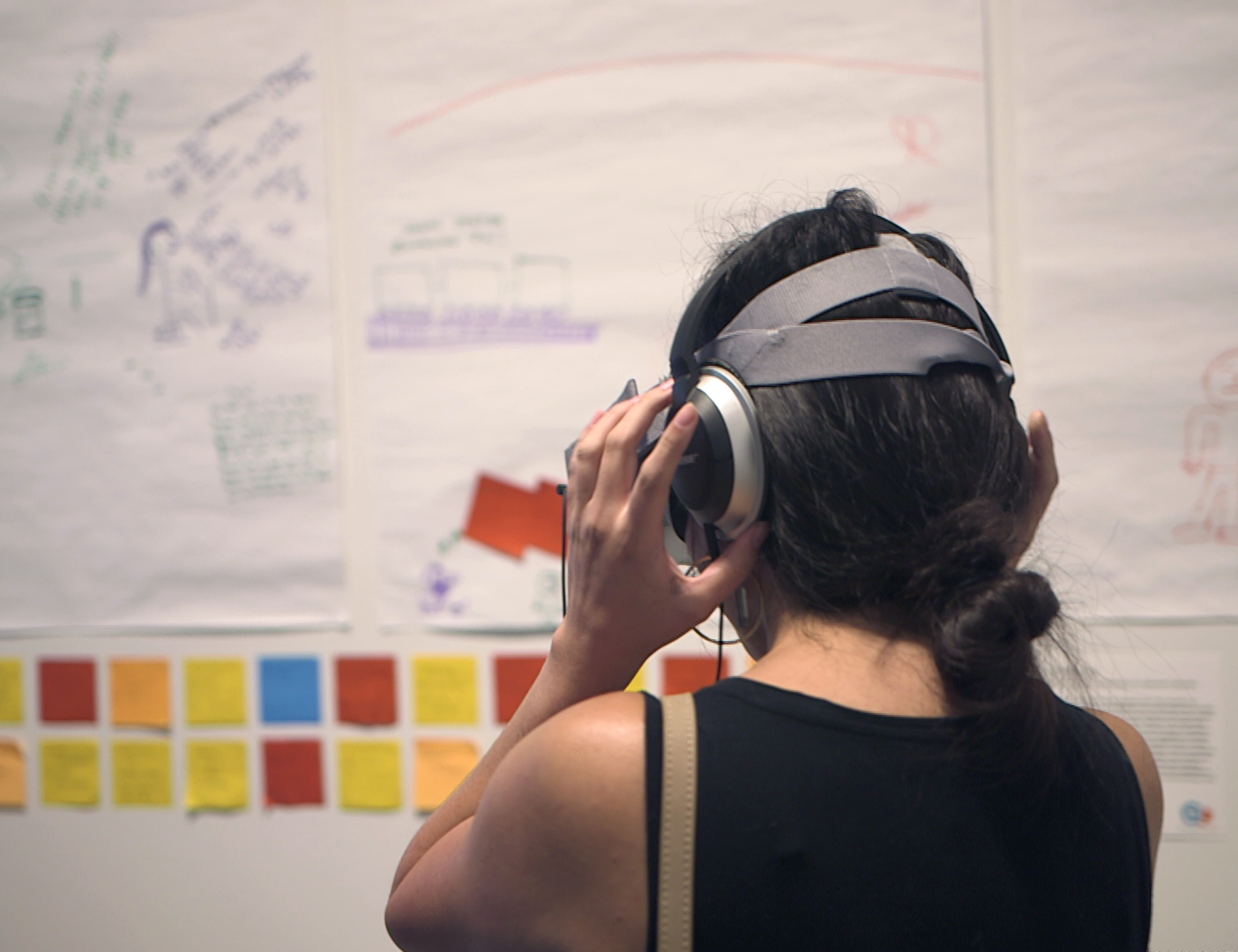 At the CMAP exhibition, Melissa Teng takes a look at her own VR short films. Behind her, research lines the walls.