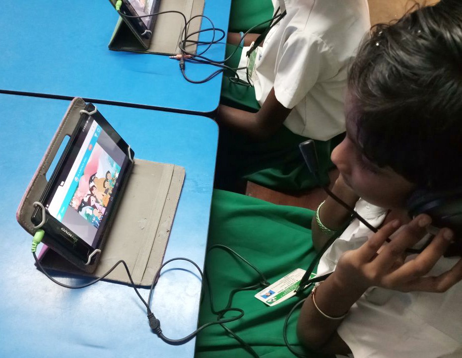Students watch Hygiene with Chhota Bheem story videos on tablets.