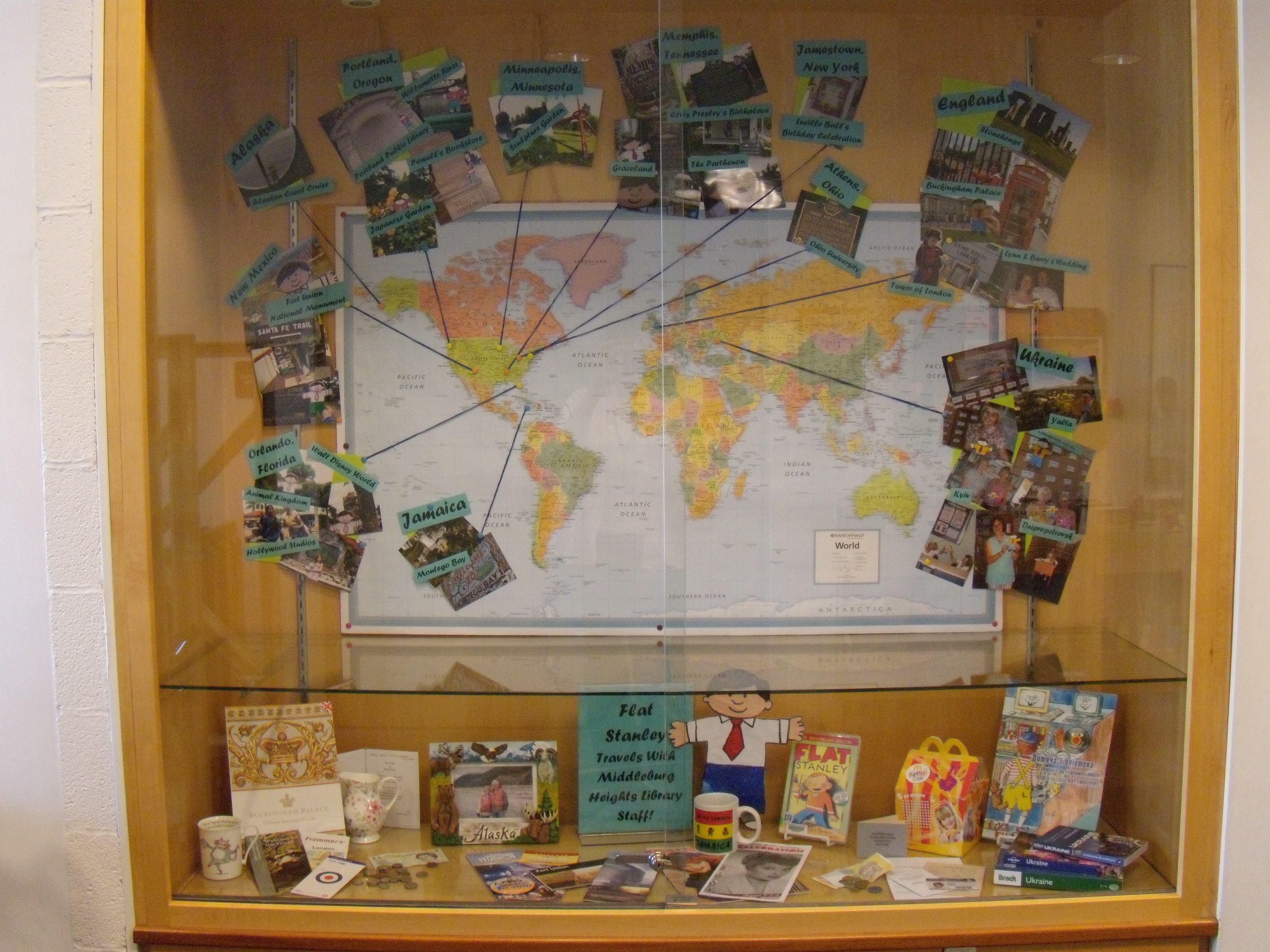 Figure 1: Many participants in the Flat Stany Project create physical maps or bulletin boards to track Stanley’s travels. This display case at the Middleburg Heights Branch Library shows the pictures, postcards, and souvenirs that accompanied Flat Stanley on his return from different parts of the U.S. and the world. Source: Cuyahoga County Public Library Middleburg Heights Branch.