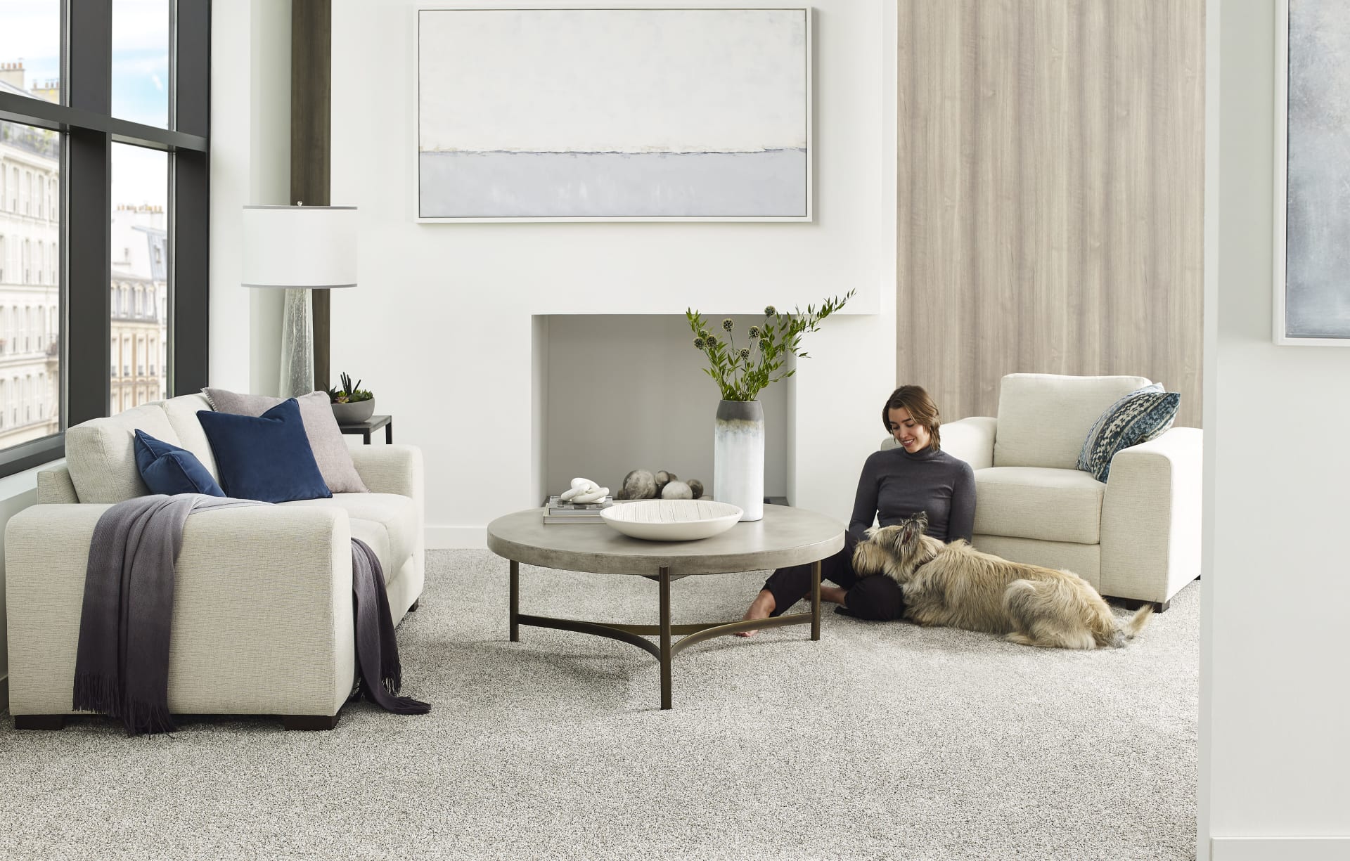 A cozy living room featuring a lady and her dog relaxing on EF carpet
