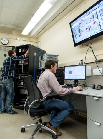 Rick Candell (seated) and Murat Aksu (standing) examining wireless communications performance in a virtual chemical processing plant created by the NIST Industrial Wireless Test Bed. (Image courtesy of Fran Webber/NIST.)