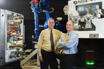 Goddard engineer Michael Kienlen (left) and SSCO deputy project manager Benjamin Reed with a mockup of the RRM now deployed aboard the ISS. (Image courtesy of NASA/Chris Gunn.)