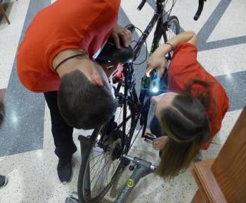 Will Caldwell and Katie Miller prepare their Safe Cycle device for demonstration at the Internet of Things Lab Open House. The system is designed to alert a cyclist to traffic behind them. (Image courtesy of David Tenenbaum/University of Wisconsin-Madison.)