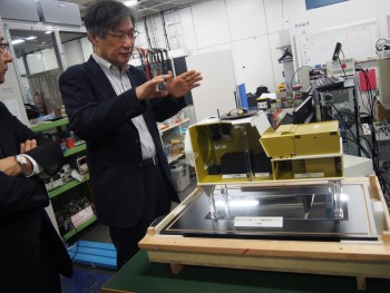 Dr. Torii demonstrates a model of the CALET. (Image courtesy of Waseda University.)