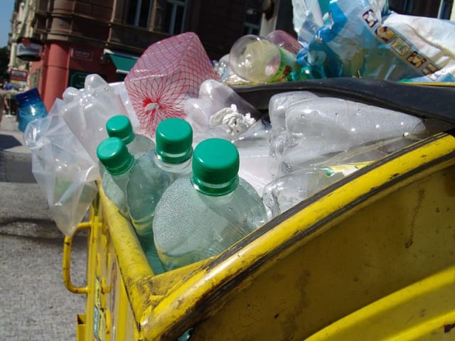 Plastic bottles overflow from a trash can in Prague. (Image courtesy of Wikimedia Commons.)