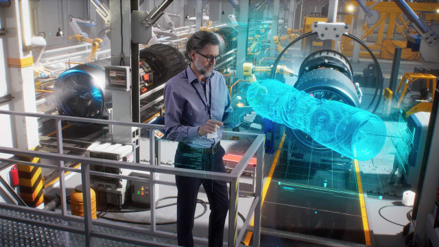 An engineer uses a tablet to model, design and monitor a 3D model of an aircraft engine while on an automated robotic line at an aerospace factory. (Image: Siemens)