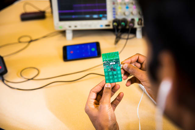 The battery-free phone developed at the UW can sense speech, actuate the earphones, and switch between uplink and downlink communications, all in real time. It is powered by either ambient radio signals or light. (Image courtesy of Mark Stone/University of Washington.)