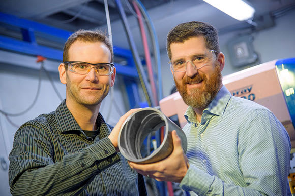 NRC researchers Jean-Michel Lamarre and Fabrice Bernier reveal a product made using their new magnet manufacturing technology. (Image courtesy of NRC.)