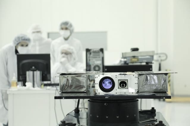 Members of the ASTERIA team prepare the petite satellite for its journey to space. (Image courtesy of NASA/JPL-Caltech.)