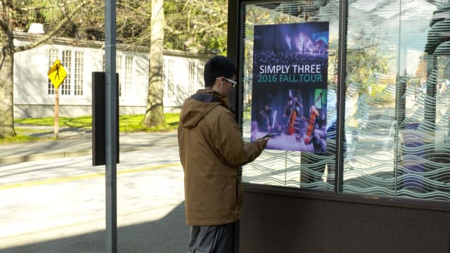 UW engineers used FM radio signals to broadcast music and data notifications from a Simply Three band poster at a Seattle bus stop to a smartphone. An antenna made of copper tape was embedded on the back of the poster. (Image courtesy of the University of Washington.)