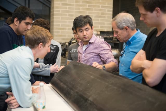 The JHO team examines one of the aircraft’s carbon fiber wings, constructed by the student team in AeroAstro’s Building 33 Neumann Hangar. (Image courtesy of MIT/William Litant.)