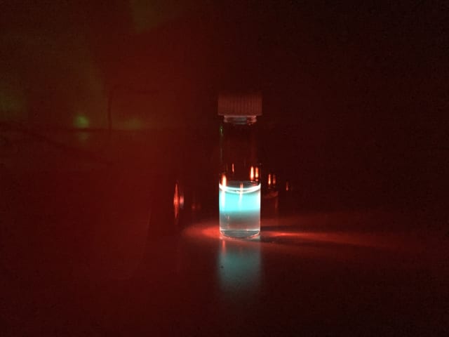 Organic nanoparticles in a vial convert invisible near-infrared light to intense blue light, which can easily be seen by human eyes.