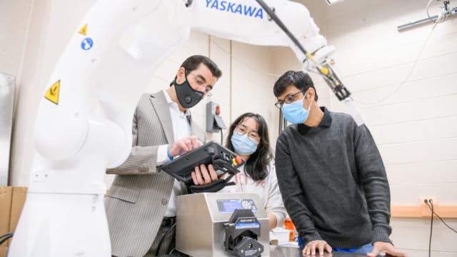 Dr. Wang discusses robotics with her colleagues.