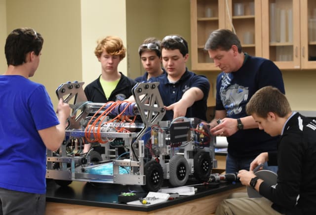 A Cyborg Cats mentor helping students with the robot for the 2016 season. (Image courtesy of Cyborg Cats.)