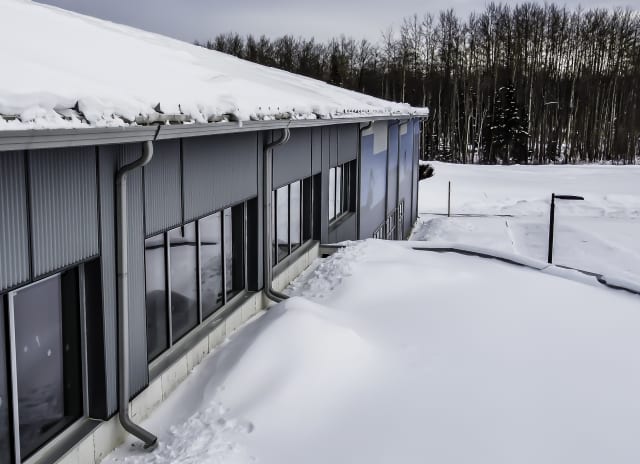 Snow loads on the Fox Creek Multiplex in northern Alberta. The fabric building features metal siding in certain sections to provide architectural variation. (Image courtesy of Legacy Building Solutions.)