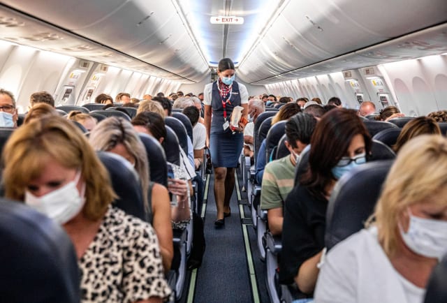 A packed flight between Amsterdam, Netherlands and Burgas, Bulgaria among one of the first international flights to resume after COVID-19. (photograph by Jeffrey Groene and Hollandse Hoog, from National Geographic)
