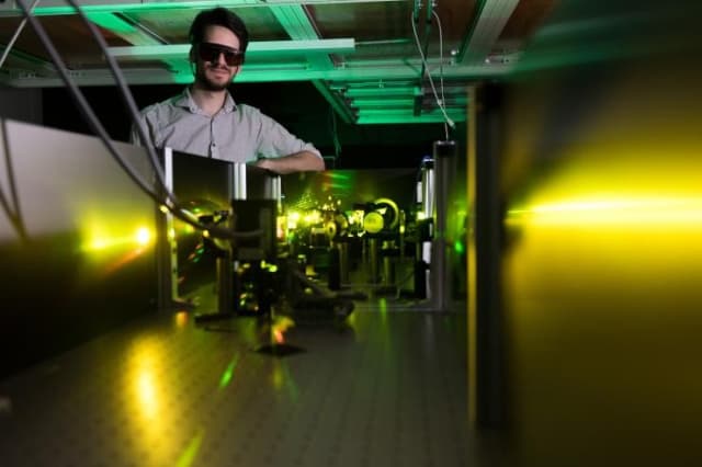 Georgia Tech graduate research assistant Felix Thouin in a lab where laser light is used to measure materials qualities. (Image courtesy of Allison Cater, Georgia Tech.)