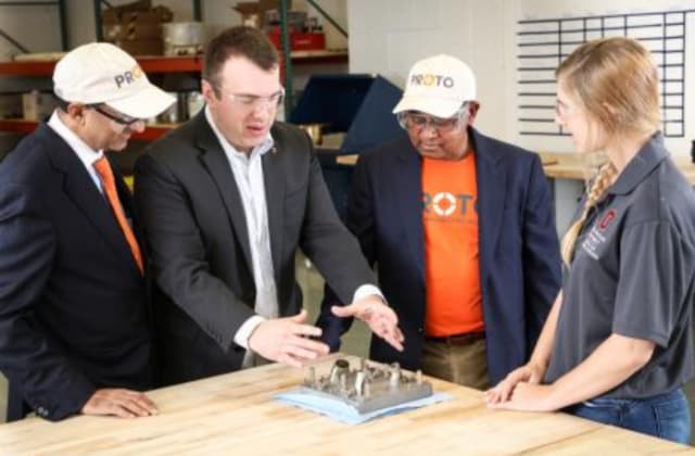 From left, John Johnson, Proto Precision; Ed Herderick, CDME; Sugu Suguness, Proto Precision; and engineering student Jordan Potts discuss the center’s first nickel alloy print from the Concept Laser metal printer. (Image courtesy of Ohio State University, College of Engineering.)