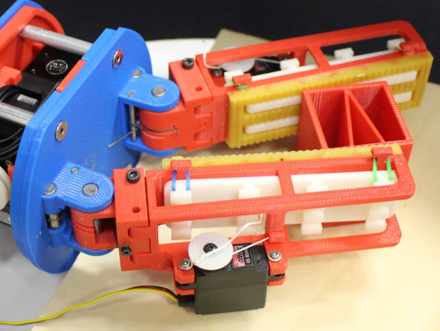 This gripper uses servos to retract the low-friction, rigid finger surface—a smooth, white surface—putting the object in contact with a high-friction deformable surface—yellow urethane rubber. (Image courtesy of GRAB Lab.)
