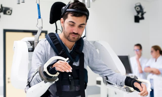 An exoskeleton controlled by a neuroprosthetic that records, transmits and decodes brain signals has made it possible for a teraplegic patient to walk and control his arms. (Image courtesy of Clinatec.)