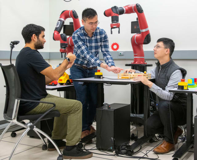 Researchers use a handheld device loaded with their software to control a robot arm. (Image courtesy of Stanford University/L.A. Cicero.)