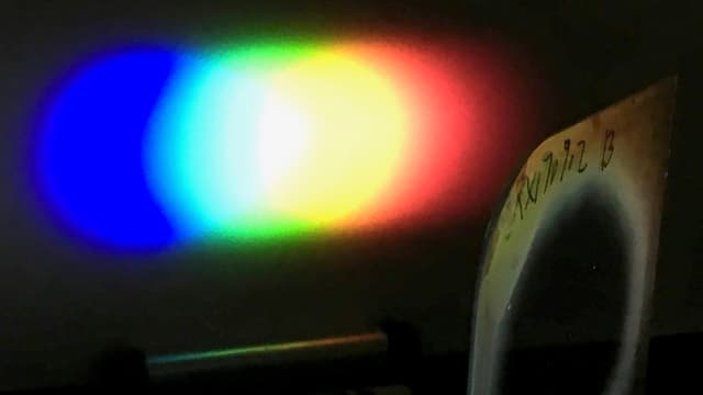 The image above shows a one-inch diameter Bragg polarisation diffraction grating bending the white light of an LED flashlight onto a screen. (Image courtesy of Michael Escuti, NC State.)
