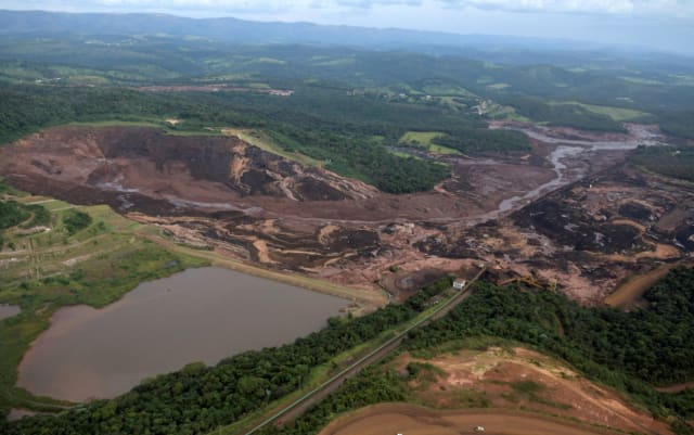 An aerial view of the collapsed dam (on the right) and the trail the mud carved through the surrounding countryside. (Image courtesy of Reuters.)