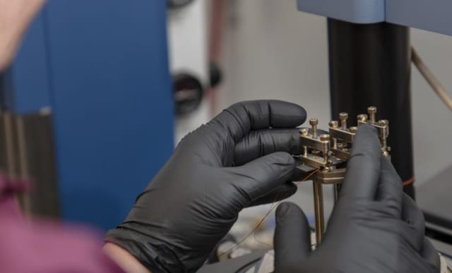 A dynamic mechanical analyzer was used to apply force on a coated cantilever 100 times. After every 10 flexes, strain was increased. The electrical resistance was measured as a function of stress to quantify the structural health monitoring sensitivity of the material. (Image courtesy of Carlos Jones, ORNL/DOE.)