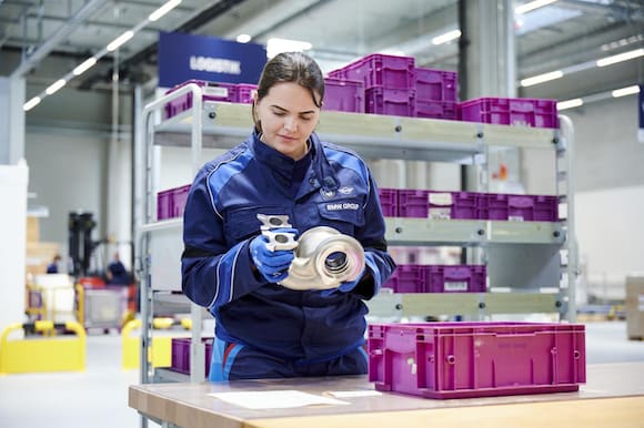 An associate inspects a metal additively manufactured component. (Image courtesy of the BMW Group.)