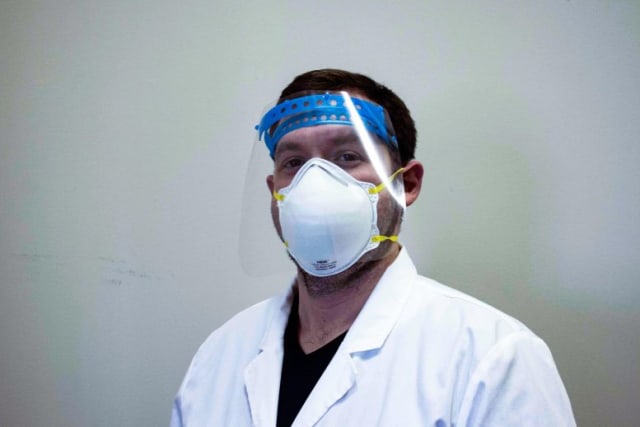 Physician David Walker models one of the face shields printed using the LAKE printer. (Credit: Northwestern University)