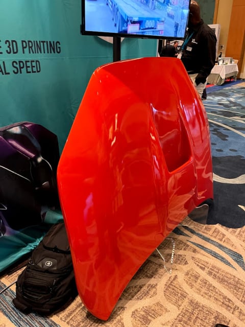 It’s massive. Massivit 3D made this automobile hood on display at AMUG 2021 as one piece. Printing took 20 hours and the material cost was $1,000.