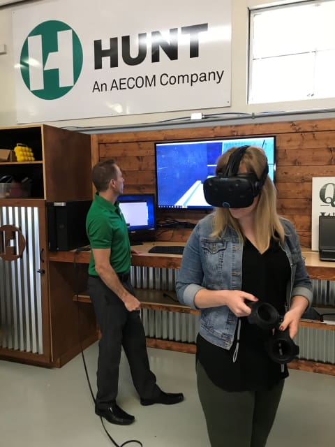 Brad Glazier, AECOM Hunt assistant VDC manager, shows a construction business owner a bit of virtual reality.