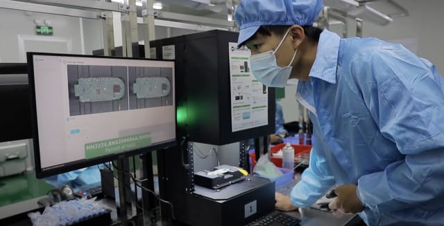 An inspection operator examines a circuit board for defects after it was flagged by AI. (Image: Instrumental.)