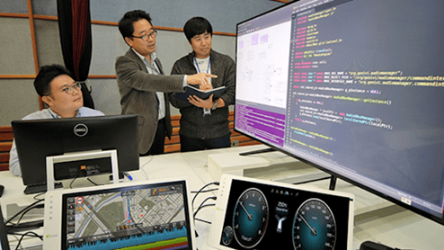 Hyundai KIA employees developing online system solution.